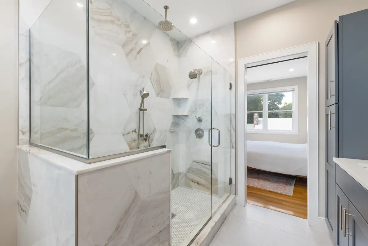 The primary bath, open through to the bedroom